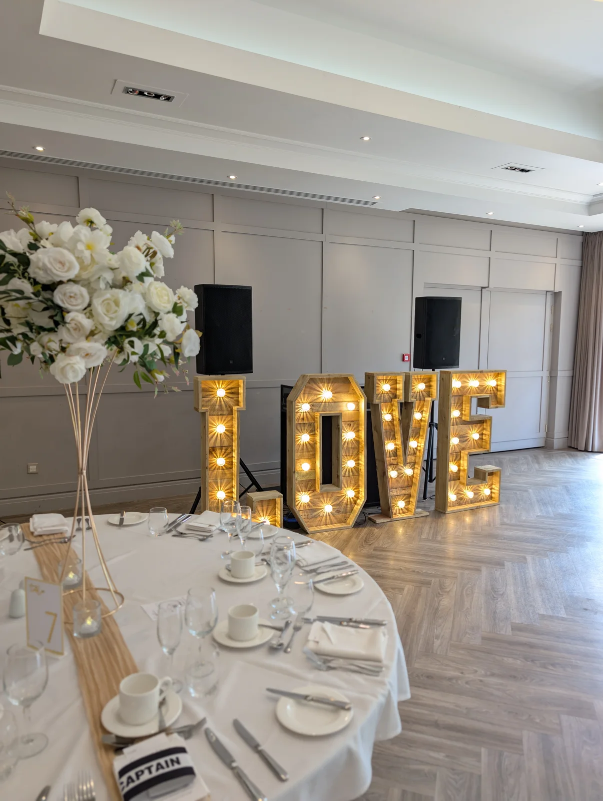 Illuminated LOVE letters beside a wedding table