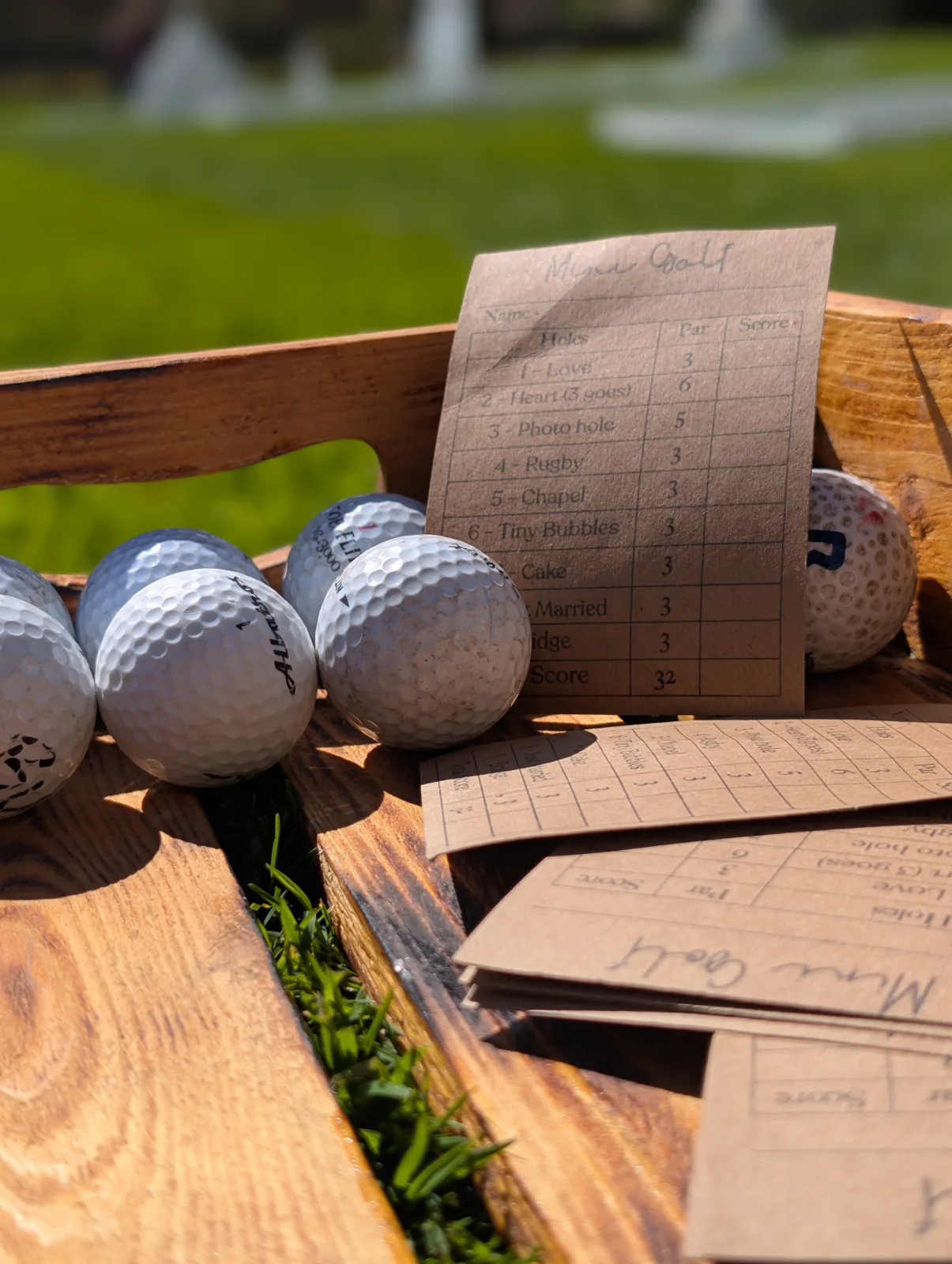 Golf balls and scorecards in a wooden basket ready for mini golf