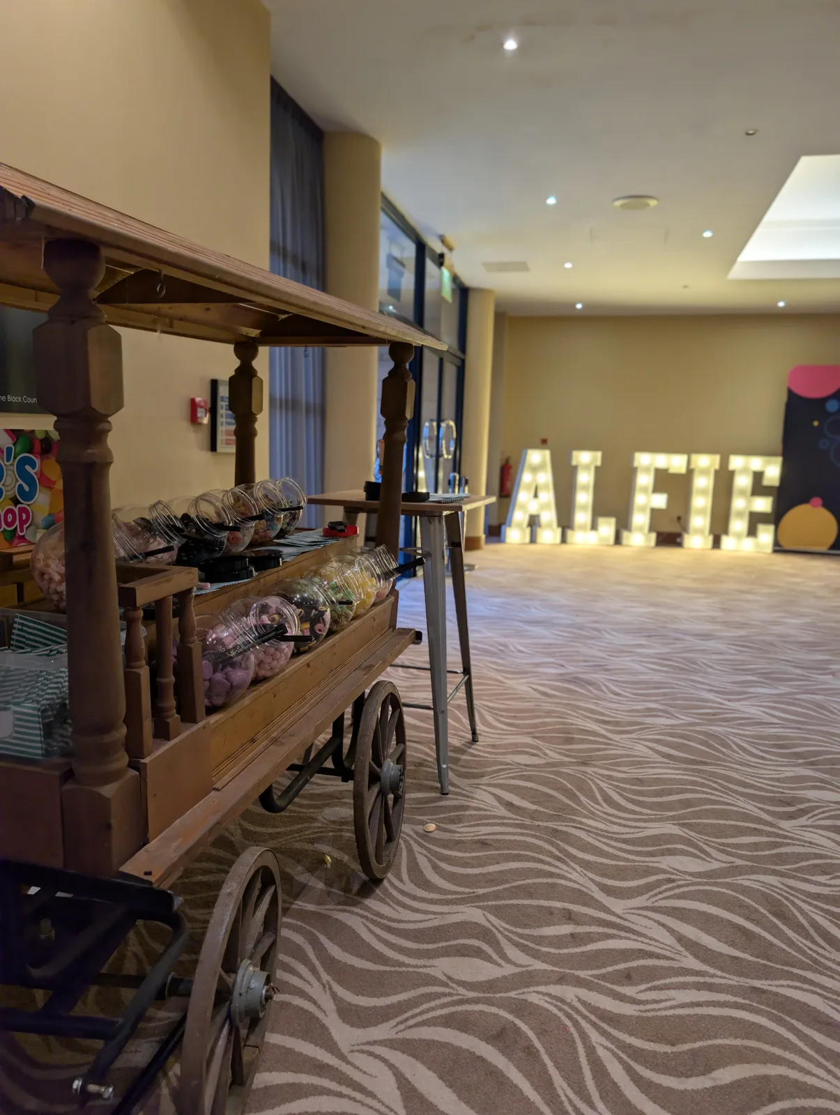 Stocked wooden sweet cart in a decorated celebration venue